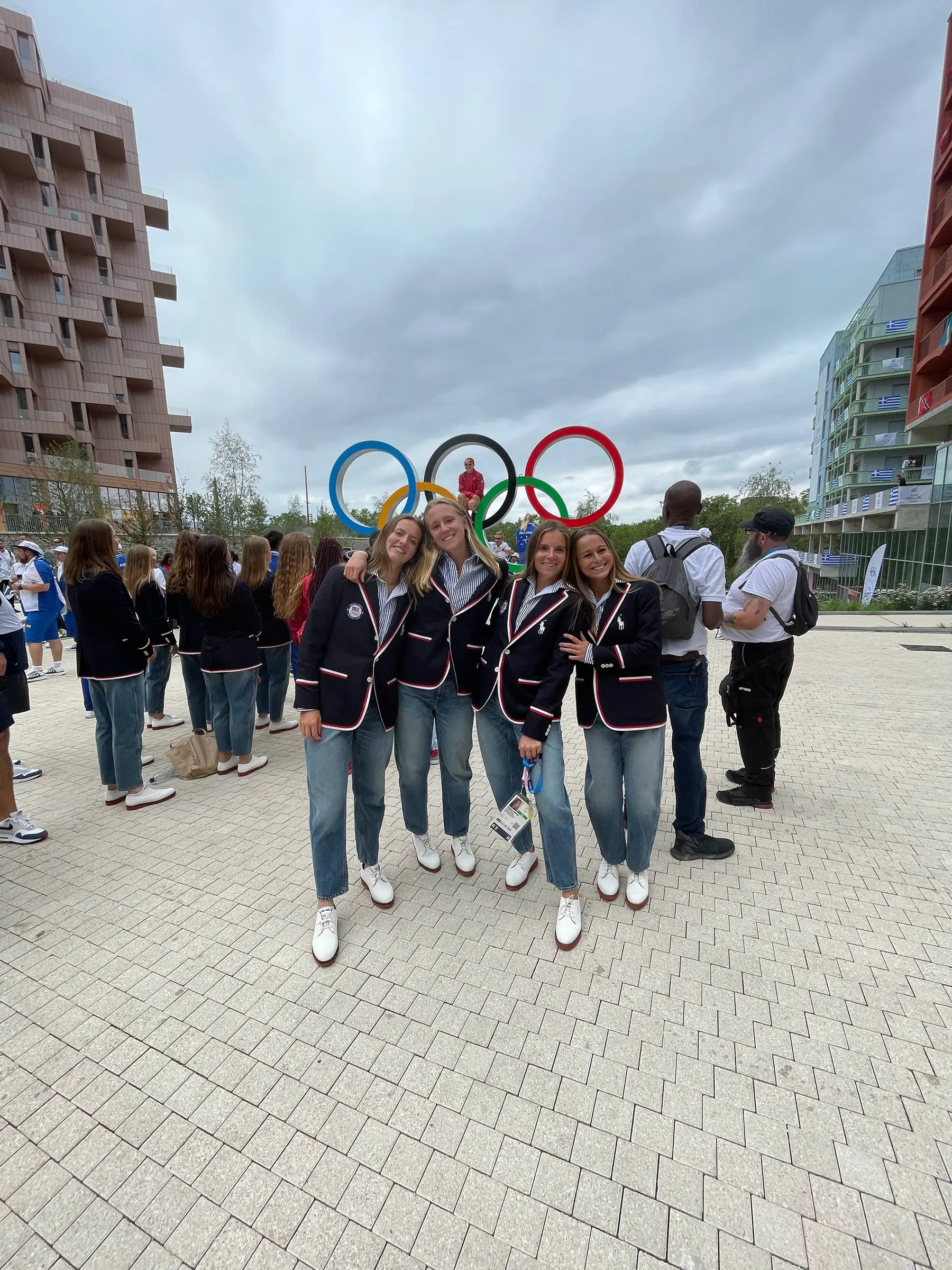 Leah Crouse and teammates pose in front of the Olympic rings.