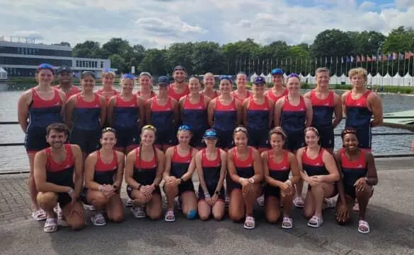 The U.S. rowing team poses together beside the regatta course.
